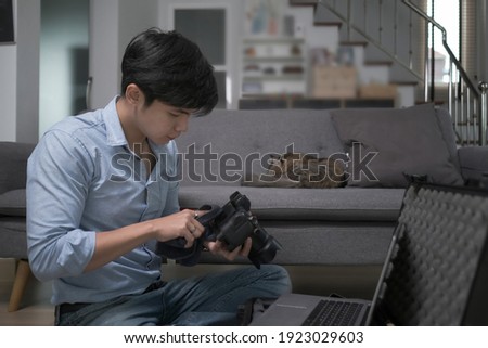 Photographer checking and adjusting his camera setting before shooting.
