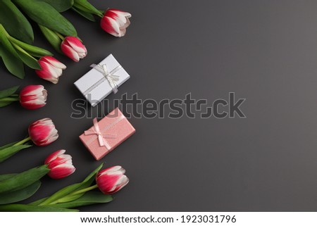 Bouquet of tulips, gift boxes on a dark background. Festive concept for Valentine's Day, Mother's Day, Women's Day and Birthday. Flatlay, copy space