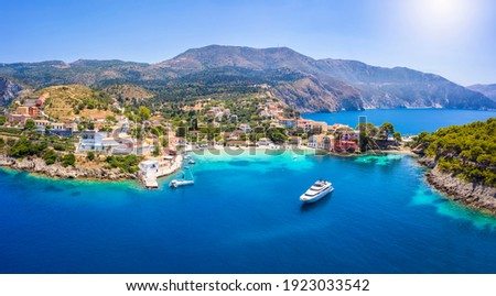 Aerial view to the beautiful fishing village of Assos on the island of Kefalonia, Greece, surrounded by turquoise sea and green hills with Pine Trees Royalty-Free Stock Photo #1923033542