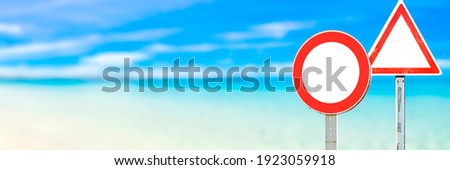 empty road sign against a blurry beach landscape, blue sky background