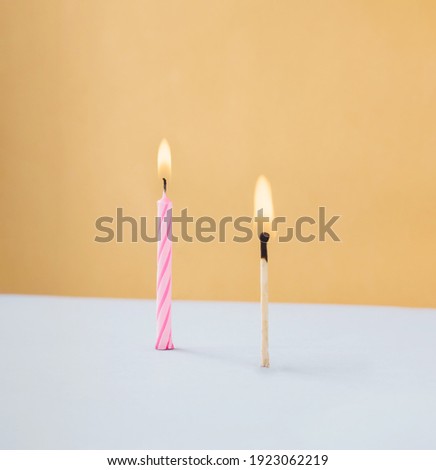 Birthday candle and matchstick with head fire. Romatic flame. Minimalist concept.