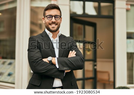 Young hispanic businessman with arms crossed smiling happy at the city. Royalty-Free Stock Photo #1923080534