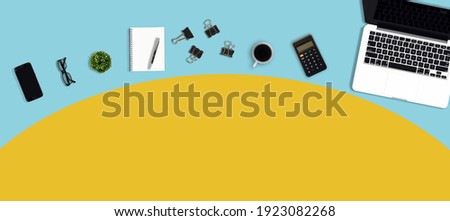 Workplace with eyeglasses, smart phone, laptop, pencil, pen