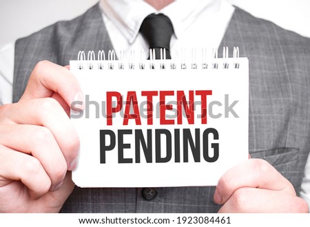 Businessman with notebook with text Patent Pending