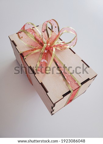 Gift in a wooden box with a bow in pastel colors