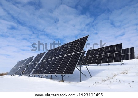 Solar panels Photovoltaic cells on a background of white and blue sky and snow. Alternative ecological solar energy. Royalty-Free Stock Photo #1923105455