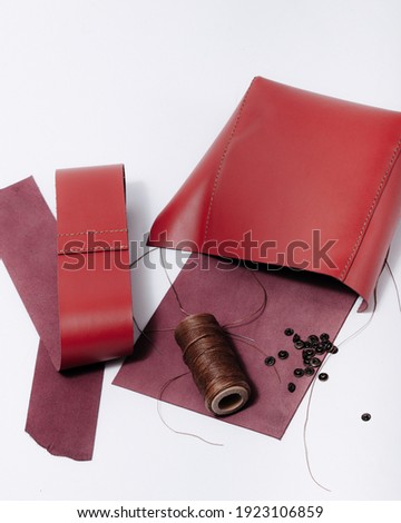 Details of a red leather bag on a white background