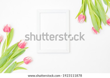 Mockup with a white frame and pink tulips on white background