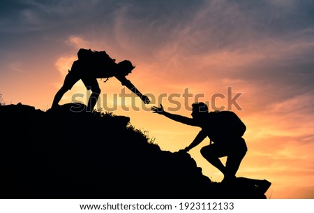 People helping each other up a mountain. Helping hand and teamwork concept.  Royalty-Free Stock Photo #1923112133