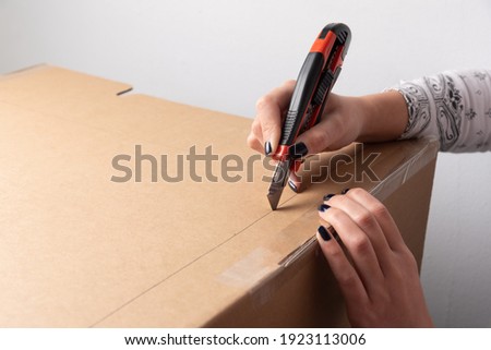 Woman hands cutting carton by marked line drawn on box with copy space for adding explanation of tutorial or guide through how to
