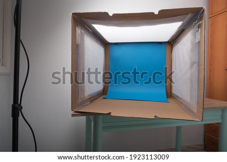 DIY light box with plain color background finished process in a home room with spotlights on wooden table