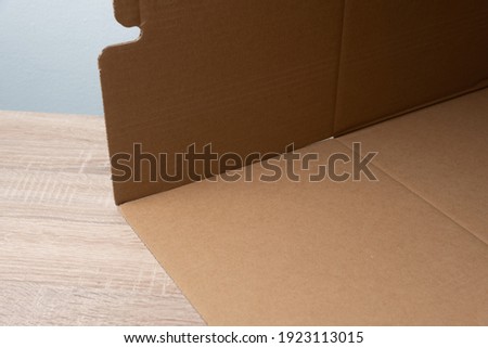 Cardboard flaps before being united by shipping tape for building a light box at home as do it yourself easily