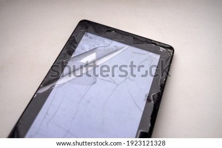 Black electronic tablet with a broken matrix and glass on a white background