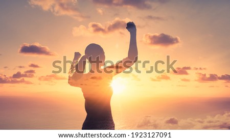 Stand strong. Woman flexing her arms in the air. Feeling motivated, strength and courage concept.  Royalty-Free Stock Photo #1923127091