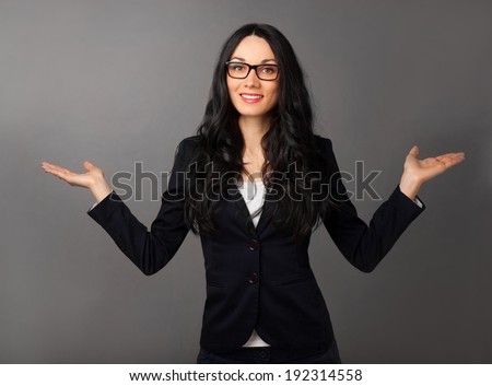 beautiful brunette woman presenting copyspace over grey background