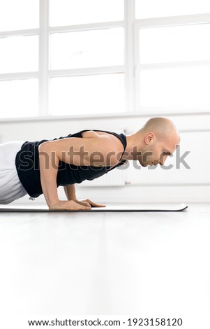 side view on man keeping balance on hands, doing yoga exercises. yoga, healthy lifestyle concept