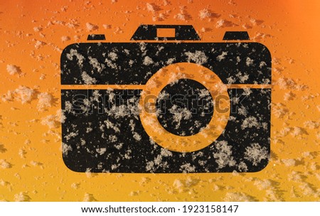 black camera icon on orange background
