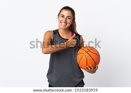 Young hispanic woman playing basketball over isolated white background giving a thumbs up gesture