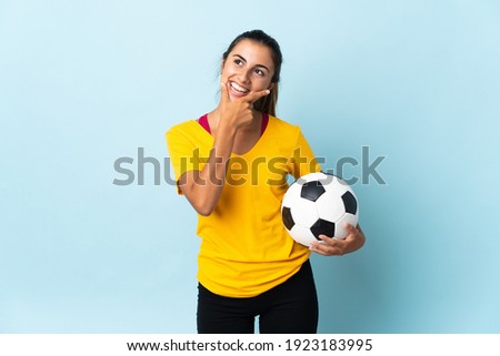 Young hispanic football player woman over isolated on blue background happy and smiling