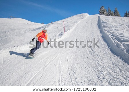 boy snowboarding down a snowy mountain slope