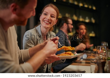 Attractive friends sitting in restaurant and having a good time. Royalty-Free Stock Photo #1923203657