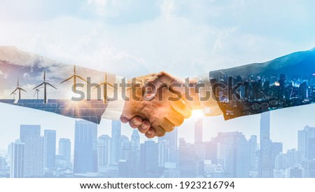 Concept of collaboration to change the world to reduce global warming,energy sources for renewable,sustainability by alternative energy.Double exposure of handshake of wind turbine and night city. Royalty-Free Stock Photo #1923216794