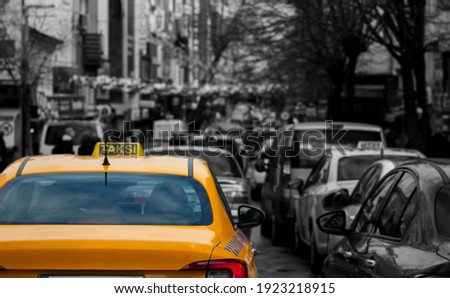 A busy street, a taxi stuck in traffic