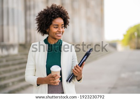 Afro businesswoman walking outdoors on the street. Royalty-Free Stock Photo #1923230792