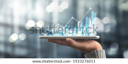 Businessman plan graph growth and increase of chart positive indicators in his business,tablet in hand Royalty-Free Stock Photo #1923276011