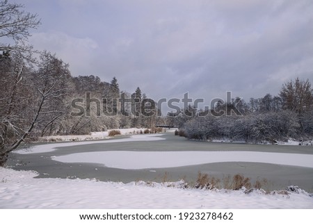 Landscape in a winter scenery with a frozen lake.