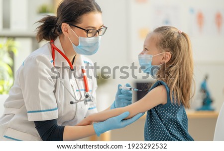 Doctor vaccinating child at hospital. Royalty-Free Stock Photo #1923292532