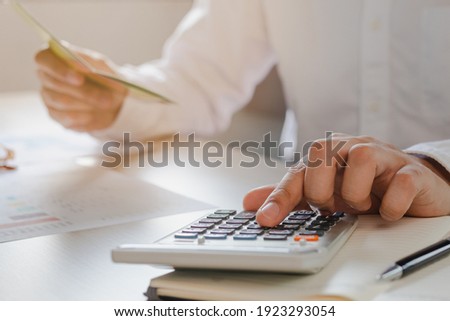 Close up hand of stress young asian businessman,male is pressing a calculator to calculate tax income and expenses, bills, credit card for payment or payday at home, office.Financial, finance concept. Royalty-Free Stock Photo #1923293054