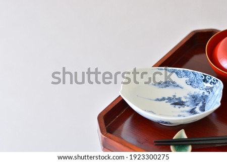 picture plate. put on a Japanese lacquer serving tray. 

This is a very fine example of Japanese traditional antique “ imari ware ”. 
blurred background soft focus image.