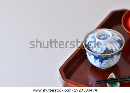 picture rice bowl. put on a Japanese lacquer serving tray. 

This is a very fine example of Japanese traditional antique “ imari ware ”. 
blurred background soft focus image.