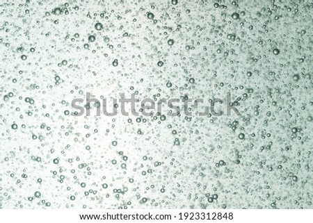 small air bubble free floating in clear liquids with light in background