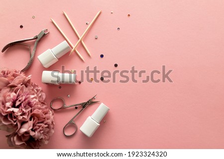 A set of manicure tools and accessories on a pink background with flowers and rhinestones. Nail care. Flat lay. Copy space. Women's Day. March 8 Royalty-Free Stock Photo #1923324320