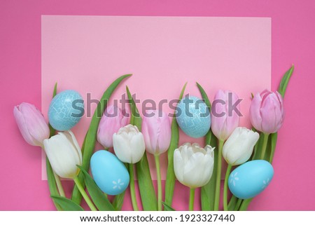 Easter holiday.Pink and white tulips flowers and blue decorative eggs on a light pink background. Easter festive background in pastel colors. copy space.Spring Religious Holiday Symbol	