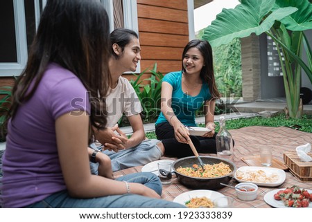 Group of asian friends having fun while eating and drinking in the backyard - Happy people together