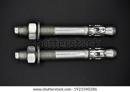Galvanized steel metal dowel with metric bolt and nut, isolated on black background
