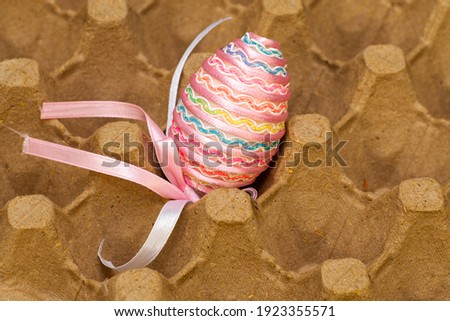 easter egg decorated with a satin ribbon in the egg stand. High quality photo
