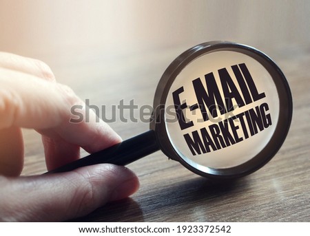 EMAIL MARKETING under magnifying glass on wooden background. Business concept.