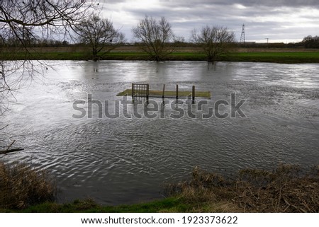 Large piece of garden decking floating down a river Royalty-Free Stock Photo #1923373622