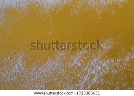 Food background flour powdered sugar scattered on a yellow bright background with a copyspace place for text photo.