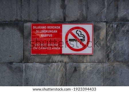 Yogyakarta, 15 December 2020: No smoking sign in the campus area. Warning written in two languages, Indonesian and English.
