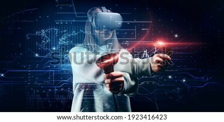 Image of a beautiful stylish woman wearing VR glasses and holding joysticks. Virtual reality concept. Mixed media