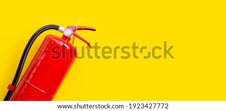 Fire extinguisher on yellow background.