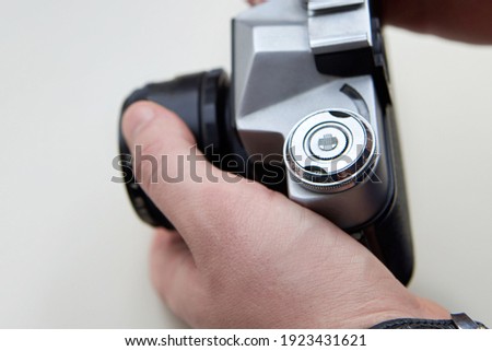 Retro camera in the hands of a man on a white background.