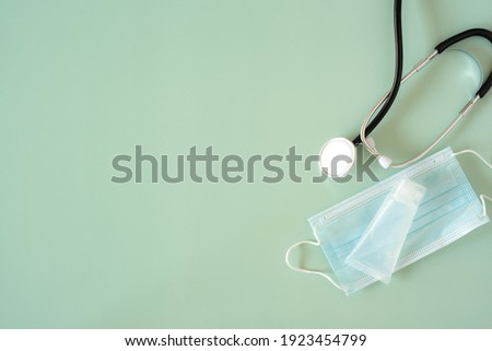 Medical devices flat lay. Thermometer, phonendoscope, surgical masks on blue background with copy space