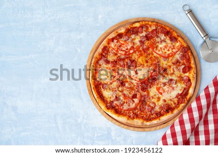 Delicious pizza with sausages on gray background