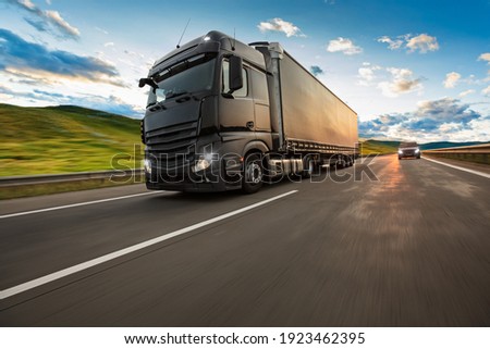 Truck with container on highway, cargo transportation concept. Shaving effect. Royalty-Free Stock Photo #1923462395